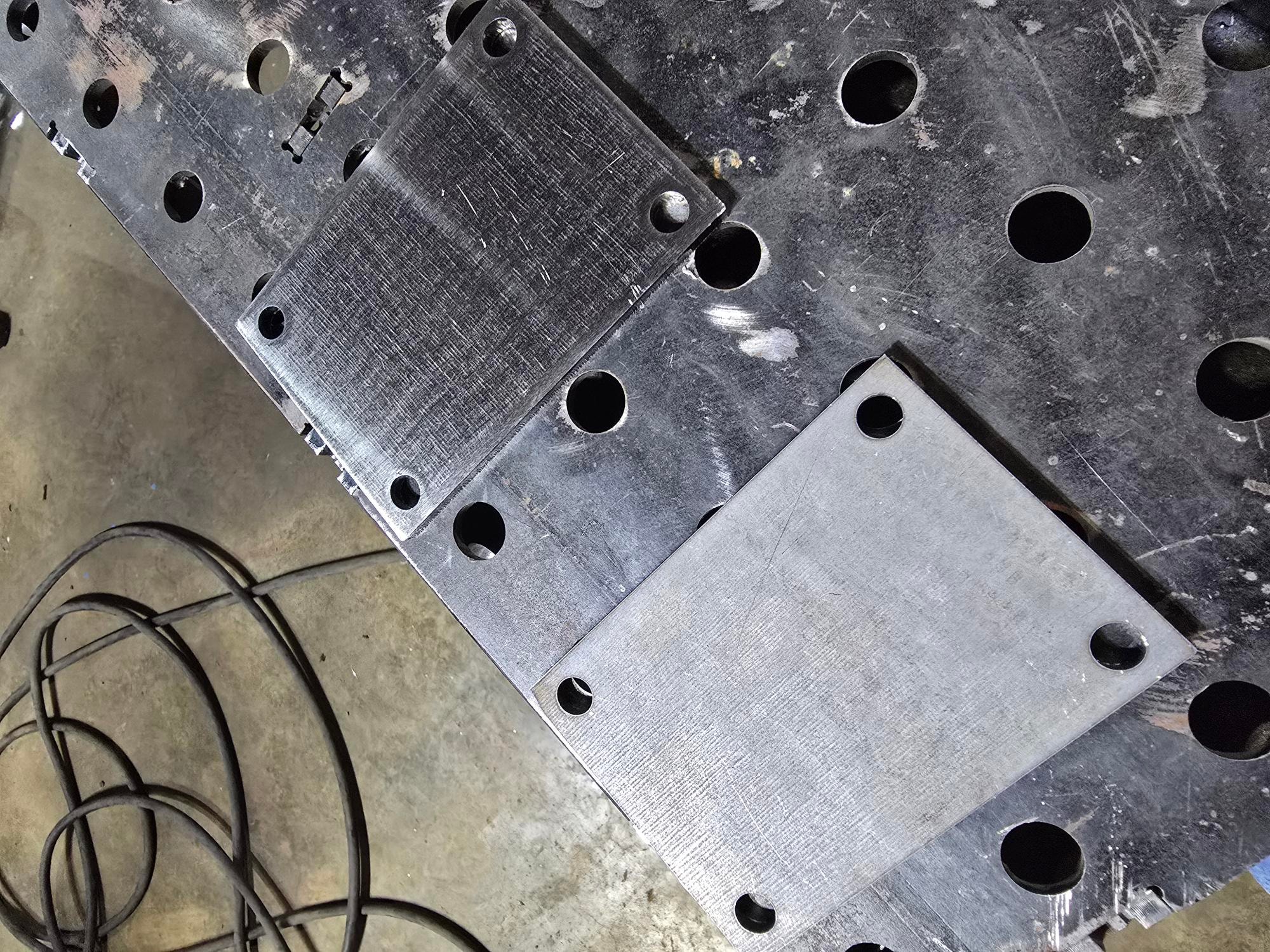 Welded metal parts with holes on a fixture table