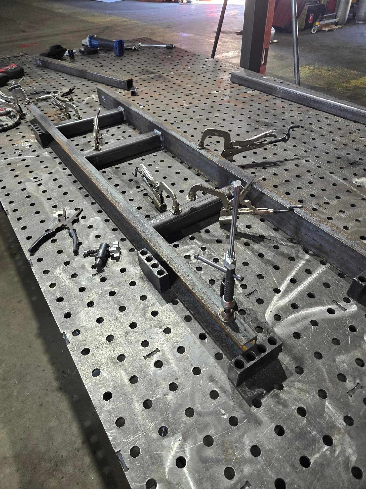 Steel tube frame clamped on welding fixture table with locking pliers